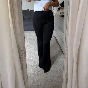Svarta yoga pants - Snygga svarta bootcut, yoga pants med mid midja. Perfekta för en stilren look. Byxorna har en tight passform upptill och vidgar sig vid anklarna för en klassisk bootcut-stil.
