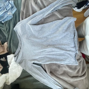 Grå långärmad tröja - Säljer en enkel och stilren grå långärmad tröja. Perfekt för en avslappnad look. Tröjan är mjuk och bekväm, idealisk för vardagsbruk.