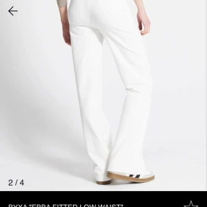 Vita byxor med snörning - Snygga vita byxor med snörning i midjan. De har en rak passform och är perfekta för en avslappnad stil. Byxorna är tillverkade i ett mjukt material som ger en bekväm känsla hela dagen.