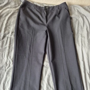 Svarta kostymbyxor från Papaya - Snygga svarta kostymbyxor från Papaya Collection med klassisk rak passform. Byxorna har pressveck, sidfickor och en bakficka med knapp. 100% polyester 