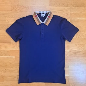 Burberry pike skjorta - 🧸✨ Burberry piké – marinblå Elegant piké i lyxig design från Burberry. 💙 Marinblå – stilren och tidlös färg 📌 Helt ny – aldrig använd, tags fortfarande kvar 🎯 Passar både vardag och mer uppklätt 📏 Storlek: M (fast passar även S)