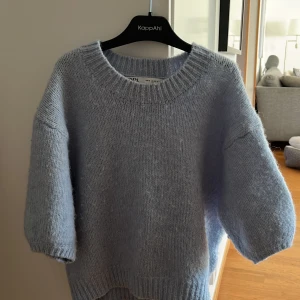 Ljusblå stickad tröja från ZARA - Supermjuk och fluffig ljusblå stickad tröja från ZARA. Tröjan har rund halsringning, långa ärmar och en avslappnad passform. Perfekt att mysa i under kyliga dagar.
