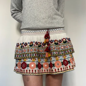 Somrig kjol🌺☀️ - Super söt  kjol från Zara, stl S,   med färgglada broderier!😍Kjolen har volanger, och resor i midjan som gör den töjbar och skön!!  Den är i bra skick, men har en mini fläck på framsidan, se bild 5!!🩷
