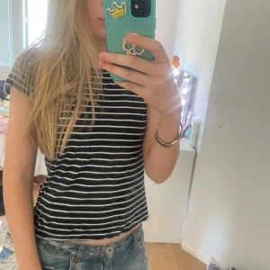 Svartvitrandig t-shirt från Lefties - Säljer en svart t-shirt med vita horisontella ränder från Lefties. Perfekt till jeans eller kjol för en avslappnad stil.