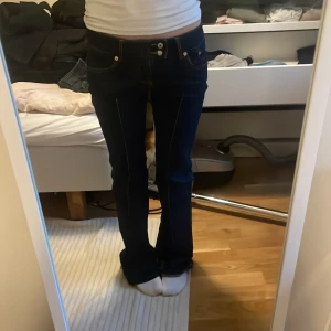 Mörkblå bootcut jeans  - Snygga mörkblå jeans med bootcut passform och klassiska kontrastsömmar. Låg midja och femficksmodell. Perfekta om du gillar en tidlös jeanslook med lite utsvängda ben.