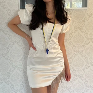 Studentklänning  - Supersnygg vit kort klänning med puffärmar och fyrkantig urringning. Klänningen har figurnära passform och en slits med pärldetaljer på ena sidan. Skicka om du har frågor 🥰🥰