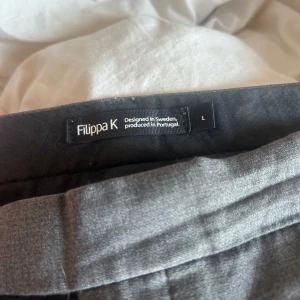 Grå kostymbyxor från Filippa K - Lågmidjade Kostymbyxor som är utsvängda vid benen, köpta här på plick men kommer ej till användning tyvärr 