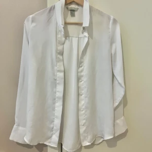 Vit blus - Säljer en stilren blus som ger en tidlös look. Knappt använd. (Storlek 34 men funkar som 36)