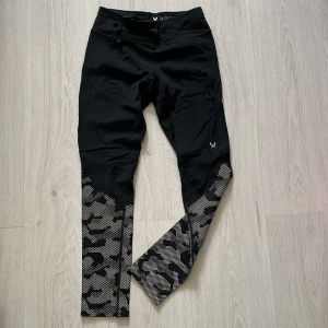 Två par svarta träningstights från SOC med mönster - Säljer två par snygga träningstights från SOC i storlek 146/152. Ena paret är svarta med knytning i midjan och reflex mönster nertill, det andra paret är svart med vitt leopardmönster. aldrig använda 60kr för båda.