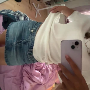 Blå jeanskjol från Zara - Säljer en klassisk blå jeanskjol från Zara i modell kortkjol. Kjolen har fem fickor, bälteshällor och stängs med knapp och dragkedja framtill. Perfekt för dig som gillar en enkel och tidlös denimstil.
