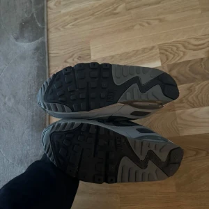 Grå Nike Air Max sneakers - Säljer ett par grå Nike Air Max sneakers med svarta detaljer och snörning. Skorna har en klassisk siluett och synlig Air Max-dämpning i sulan. Perfekta för dig som gillar streetwear och sportig stil.