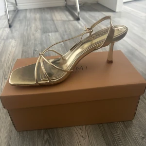 Guldiga klackar  - Säljer ett par  guldiga klackar från Asos. Skorna har en medelhög klack. Säljer då jag råkade köpa två av varje storlek. Passar perfekt till sommaren och är väldigt sköna!🩷De är helt nya i förpackning.