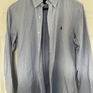 Ralph Lauren  - Här har vi en svin fet ljusblå raffe skjorta! Storlek M men kan också passa S.                           Denna skjorta är i svin bra skick och har knappt varit använd, perfekt för dig som vill va riktigt snygg under sommarn!