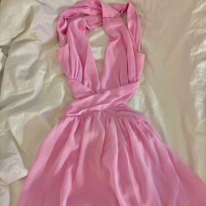 Rosa miniklänning  - Klänningen är från Nelly och är i storlek 32. Är lite insydd vid banden men går jättebra att sprätta upp