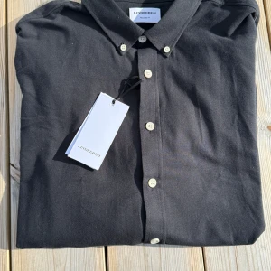 Svart skjorta från Lindbergh XXL - Klassisk svart skjorta från Lindbergh i storlek XXL. Den är helt ny, aldrig använd då jag fick den i present och det var fel storlek. Prislapp kvar!