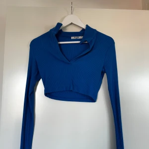 Blå ribbad croppad topp från NA-KD - Snygg, blå croppad topp från NA-KD med ribbad struktur och v-ringning. 