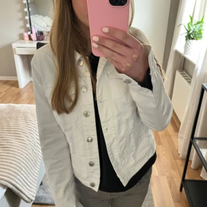 Vit jeansjacka - Säljer en stilren vit jeansjacka med knappar framtill och två bröstfickor från Vero Moda. Jackan har en klassisk krage och långa ärmar, perfekt för vår och sommar. Endast använd ett fåtal gånger och i mycket bra skick💕