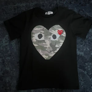 Cdg T-shirt  - Säljer en fet T-shirt från Play Comme des garcon i storlek s. Tröjan är för liten för mig men passar den mellan 180-170cm. Tveka inte på att skriva. Priset är ej hugget i sten