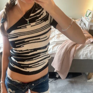 Svart och vit randig topp från Lindex - Snygg svart och vit randig topp från Lindex i storlek XS. Toppen har en unik one-shoulder design och korta armar. Använd en gång eftersom att den inte riktigt är min stil.