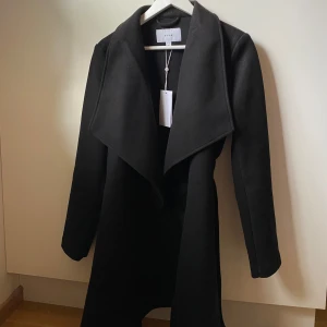 Svart kappa från Vila - Superfin helt ny svart kappa från Vila med prislappen på! Storlek S, nypris 600kr.
