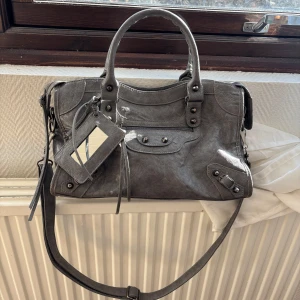 Balenciaga väska grå - Säljer denna så snygga och trendiga väska som liknar den från Balenciaga! Den är i största storleken och rymmer väldigt mycket❣️perfekt till vardagen! (Obs! Spegeln saknas men annars är väskan i toppskick)