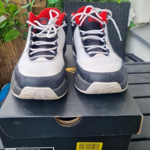 Nike Air Jordan Max Aura 3 - Snygga Nike Air Jordan Max Aura 3 sneakers i vitt, svart och rött. Skorna har en klassisk snörning och en robust sula med det ikoniska Jumpman-logotypen i rött. Perfekta för dig som älskar en sportig och stilren look.