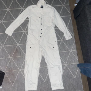 Vit overall - Nyskick utan prislapp, säljer då den inte passar på mig. Har två framfickor och nederdelen är likt cargobyxor. Perfekt studentoverall!🔥 