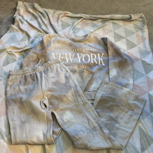 Beige sweatshirt från Kappahl - Säljer en beige sweatshirt och matchande byxor till från Kappahl. Tröjan har  texten 'New York Long Island Harbor Since 1991' tryckt på framsidan. Tröjan har långa ärmar och en avslappnad passform. Perfekt för en casual look! Nytt skick då detta ej passar och inte är min stil riktigt.