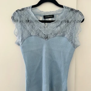 Ljusblå ribbad topp med spetsdetaljer - Ljusblå topp från misay one size, aldrig använd💕