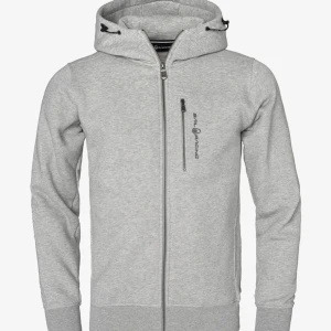 Grå hoodie från Sail Racing - Säljer en grå hoodie från Sail Racing med dragkedja och justerbar huva. Har defekter längst ner på tröjärmen men inget som stör. Ny pris 1500 från zalando. Storlek 176 och sitter som en S. Hör av dig vid intresse! 