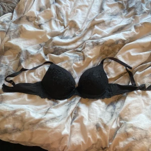 Svart spets-bh - Snygg svart bh med spetsdetaljer och justerbara axelband. Perfekt för en elegant look.