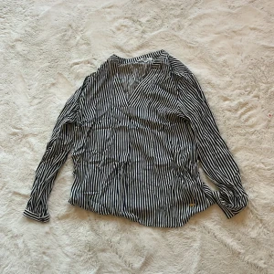 Randig blus från Hampton Republic - Snygg randig blus från Hampton Republic i svart och vit. Blusen har en v-ringad design och långa ärmar, perfekt för en stilren look. Passar bra till både jeans och kjol.