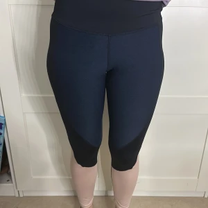 Svart och beige leggings - Snygga leggings i svart och beige med textdetalj längs benet. Perfekta för träning eller en avslappnad dag. De har en tight passform och är tillverkade i ett stretchigt material för bästa komfort.