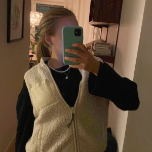 Vit teddyväst från ONLY - Säljer en mysig vit teddyväst från ONLY i storlek m. Västen har en dragkedja framtill och en praktisk bröstficka. Perfekt för lager-på-lager under kyliga dagar.