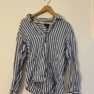 Randig skjorta från H&M - Säljer en stilren blå- och vitrandig skjorta från H&M. Skjortan har långa ärmar och en klassisk krage. Perfekt för en avslappnad men ändå snygg look. Passar bra till både jeans och chinos.