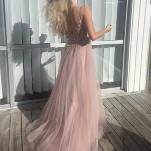 Rosa balklänning  - Säljer denna fina ljusrosa balklänning. Klänningen har spets upptill, en djup rygg och ett flödande tyll. Nypris på klänningen är 3000kr + 300kr frakt, och den är helt slutsåld i alla storlekar. Märket är mascara london. Helt ny och aldrig använd med lapparna kvar! Måtten är ca 85 cm vid bysten och 72 cm vid midjan.                                                                                                                                  Jag är 164 cm och har inga skor på mig på bilderna.