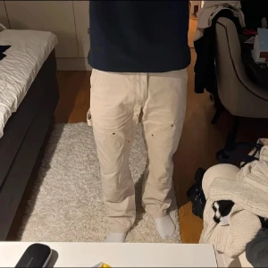 Beige carpenter pants - Beiga snickarbyxor från Topman i jättefint skick! 100% bomull. Passformen är lös/baggy. Dm för fler bilder Mått: Midja: 40 cm Längd: 102 cm Benöppning: 21 cm Lår: 30 cm