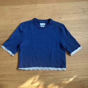 Trekvarts ärmad tröja med spetsdetaljer!!💙💙 - Säljer en snygg blå tröja från These Glory Days med fina spetsdetaljer vid ärmslut och nederkant. Tröjan har en croppad passform och trekvartsärmar, perfekt för en stilren look. Tillverkad i mjuk merinoull för extra komfort. Tröjan har jag sytt om själv från en tjocktröja!