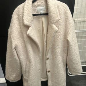 Beige teddyjacka från Vila - Mysig beige teddyjacka från Vila med knappar framtill. Perfekt för kyliga dagar med sin fluffiga och varma design. Jackan har en klassisk krage och långa ärmar.Använd max 5 gånger.  Nypris 949, pris kan diskuteras☺️💗