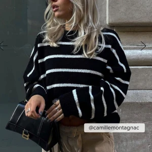 Svart och vit randig stickad tröja - FRIFRAKT Säljer en snygg svart och vit randig stickad tröja med långa ärmar. Perfekt för en stilren look. Tröjan har en avslappnad passform och är supermjuk och bekväm. Perfekt en sommarkväll