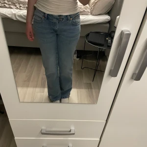 Blå jeans  - Snygga blå jeans med broderade detaljer på bakfickorna. De är lågmidjade och använts 1 gång. Storlek M/Short