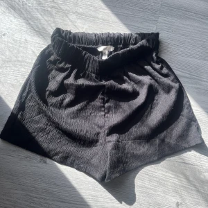 Sköna shorts från hm  - Ett par svarta shorts från hm perfekt till sommaren att dra över bikinin i ett luftigt svart tunt tyg! Storlek 38 men passar 36