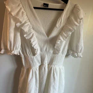 Vit klänning från Gina Tricot - Vit klänning, perfekt till sommaren. Bara använd en gång, nytt skick. Den är från Gina tricot, klänningen är i storlek M.💞