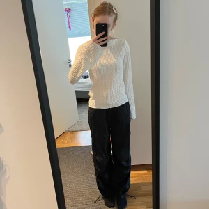 Svarta parachute byxor - Säljer ett par svarta parachute byxor från H&M med elastisk midja och flera praktiska fickor. Byxorna har en loose passform och är perfekta för en avslappnad stil. De är tillverkade i ett lätt och bekvämt material. De är i storlek xs och har inga defekter och knappt använda💕