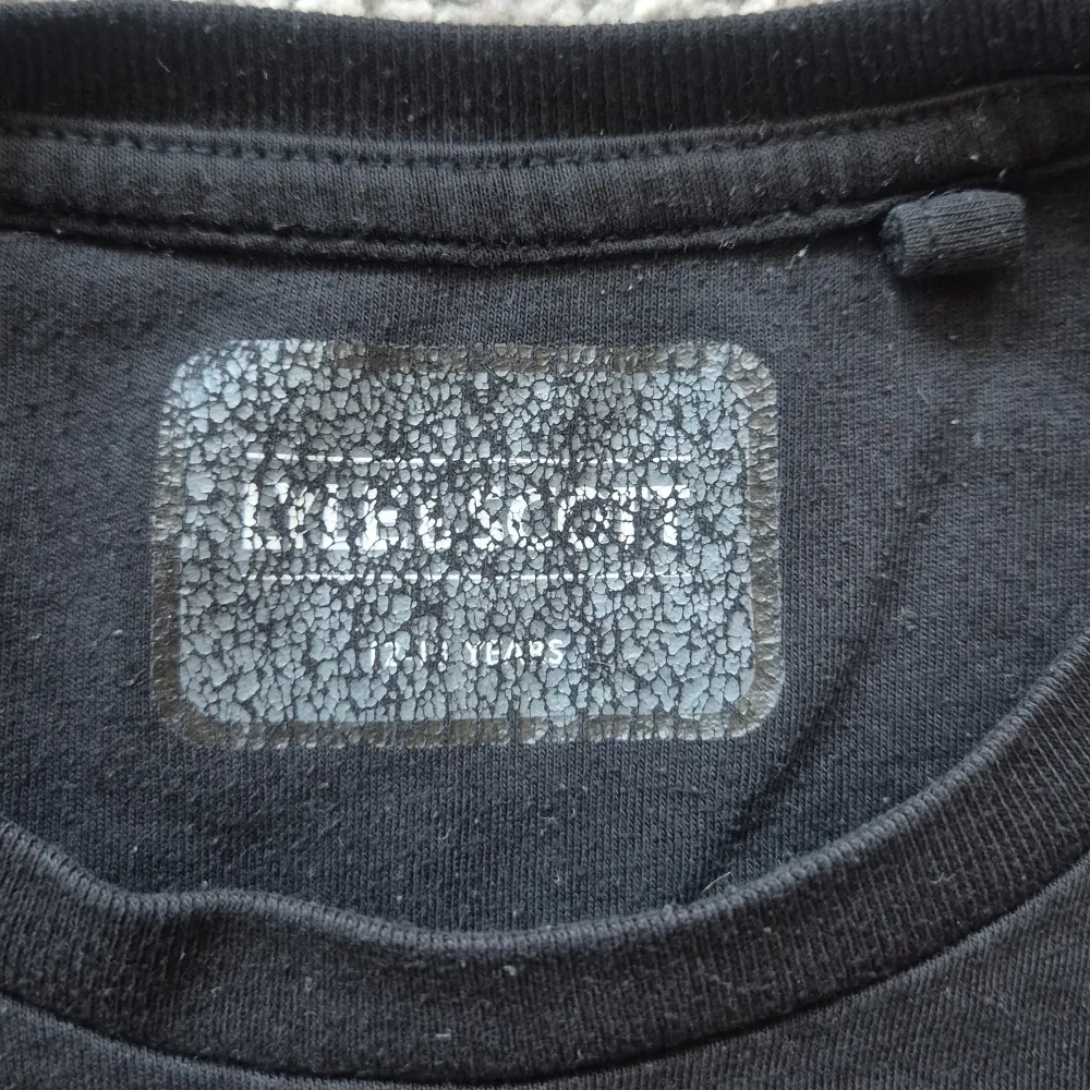 Säljer en svart t-shirt från Lyle & Scott med en gul broderad logga på bröstet. T-shirten är kortärmad och gjord i bomull, perfekt för en avslappnad stil. Storleken är till barn mellan  12-13 år. T-paidat.
