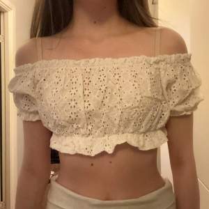 Säljer en söt vit offshoulder blus med broderade detaljer och volangkant från Pull and Bear. Man kan bära den på två sätt (se bilder). Aldrig använd