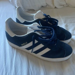 Adidas Gazelle i blått och vitt - Säljer ett par klassiska marinblå Adidas Gazelle sneakers i storlek 38.  Skorna är knappt använda så i mycket fint skick😊 skriv för frågar🤗