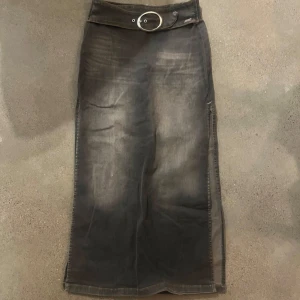Grå långkjol från BDG jeans - Fin grå långkjol från BDG med silver bälte i metall och dragkedja bak. Kjolen är i bra kvalité 8/10 och skönt jeans material som inte sitter åt.