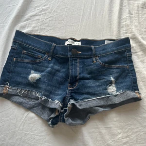 Mörkblå jeansshorts från Abercrombie & Fitch - Säljer ett par snygga mörkblå jeansshorts från Abercrombie & Fitch. De sitter så snyggt på men säljer då dom ör lite för stora för mig. Står storlek 28 men skulle säga att dom sitter som S🥰