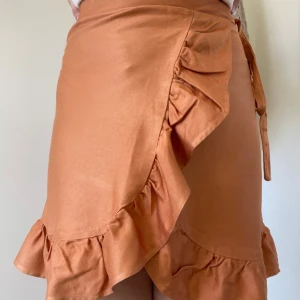 Orange omlottkjol med volang - Snygg orange omlottkjol med volangdetaljer  - egensydd, endast använd ett fåtal gånger.  @sytanten_ (Instagram)